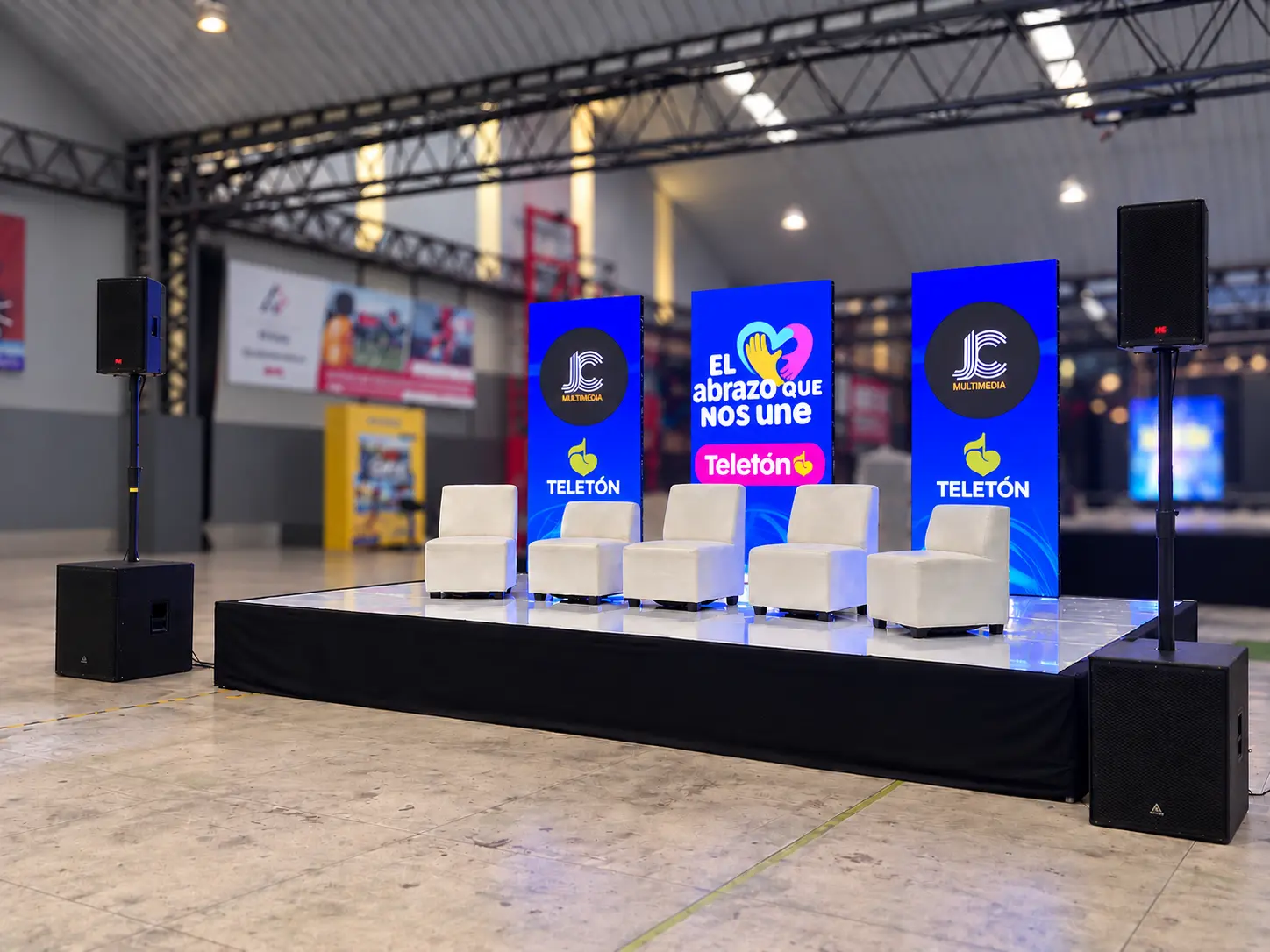 Sillones lounge blancos en tarima con pantallas LED y sonido para evento en El Salvador